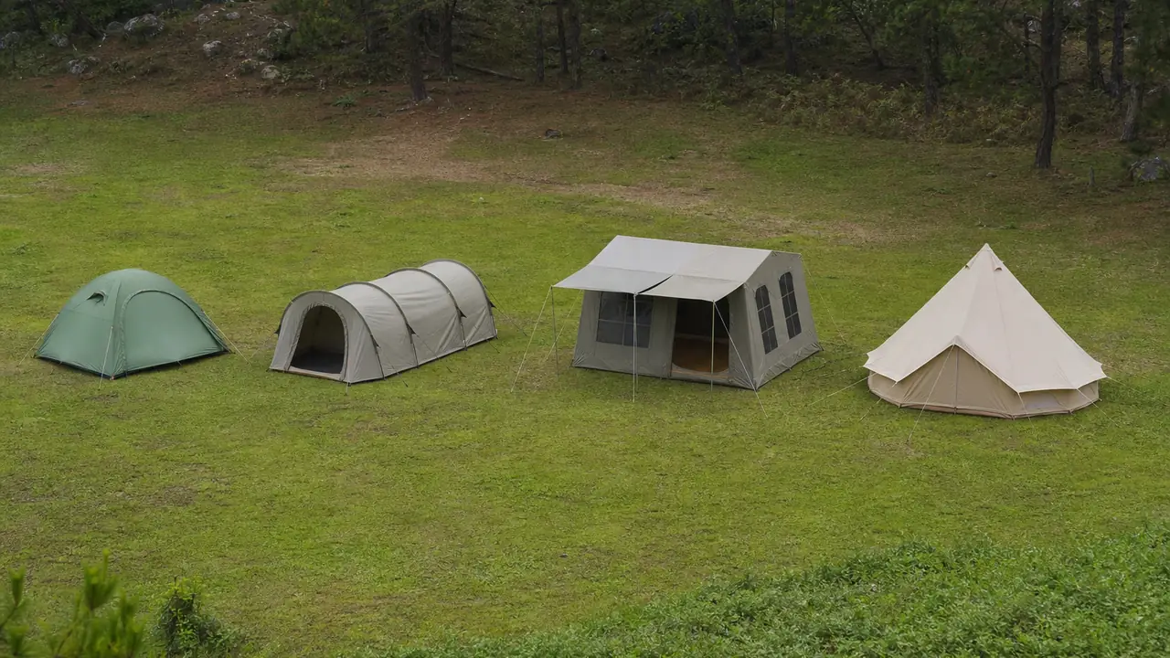 Szene zum Leitfaden Zelttypen: Kuppelzelt, Hauszelt, Faltpavillon und Glockenzelt aus Canvas nebeneinander auf einer Wiese