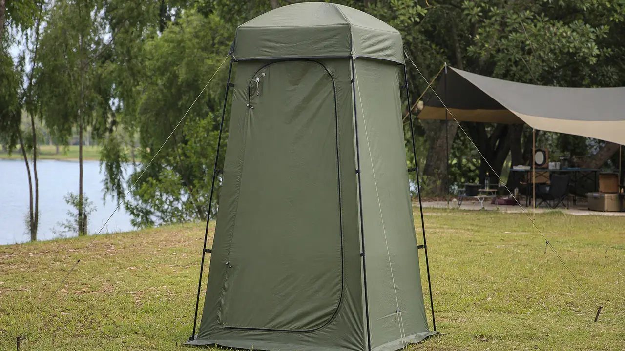 Alta tenda doccia e spogliatoio pop-up con punto di aggancio sul tetto e tiranti picchettati in un campeggio